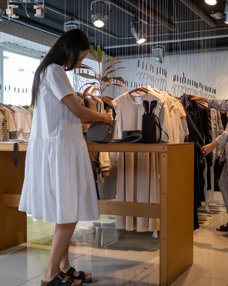 Modern klädbutik med kläder och kunder