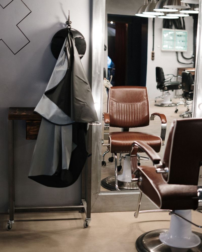 Modern barbersalong med läderfåtöljer och spegel